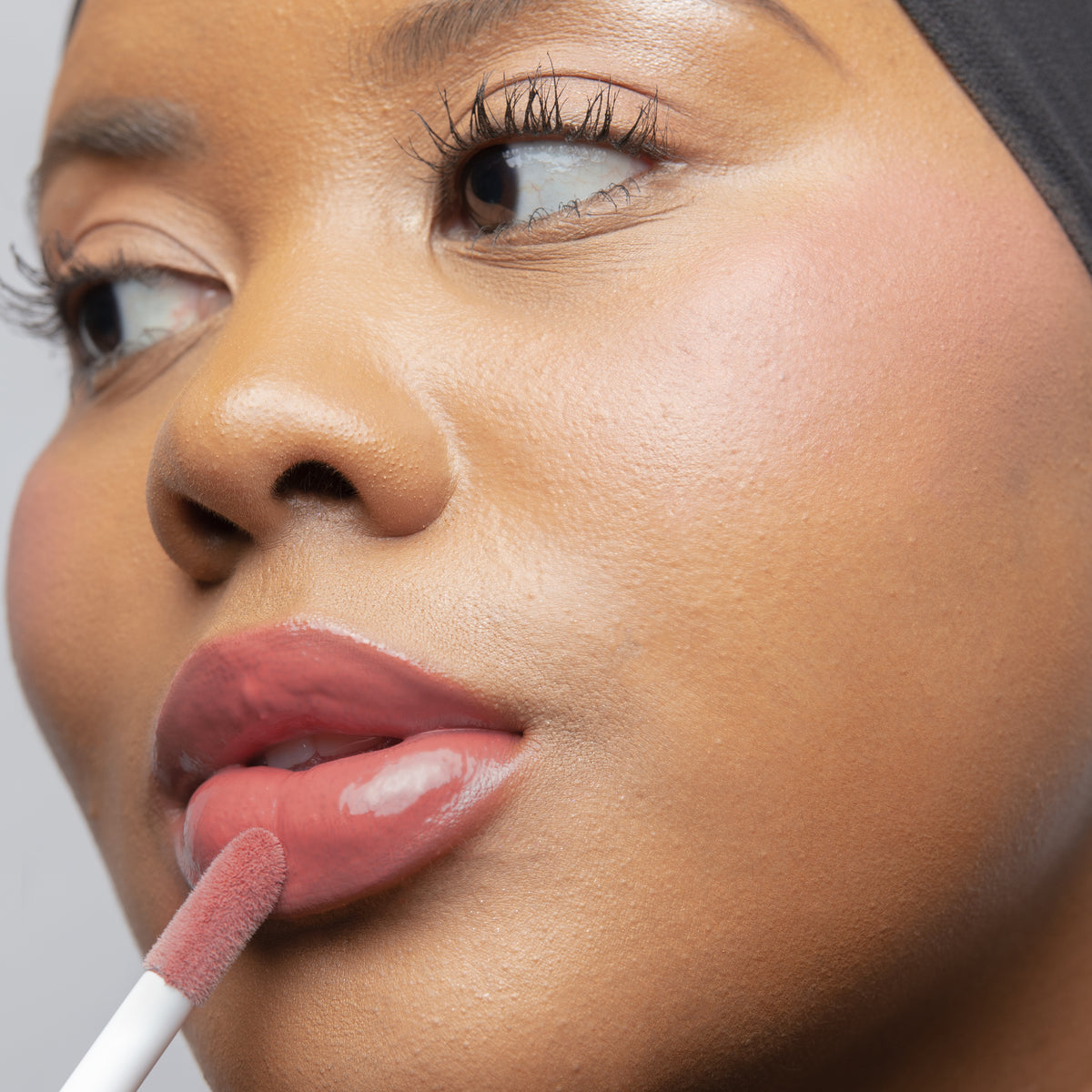 Peptide Glo Lip Glaze in Cameo on tan skin