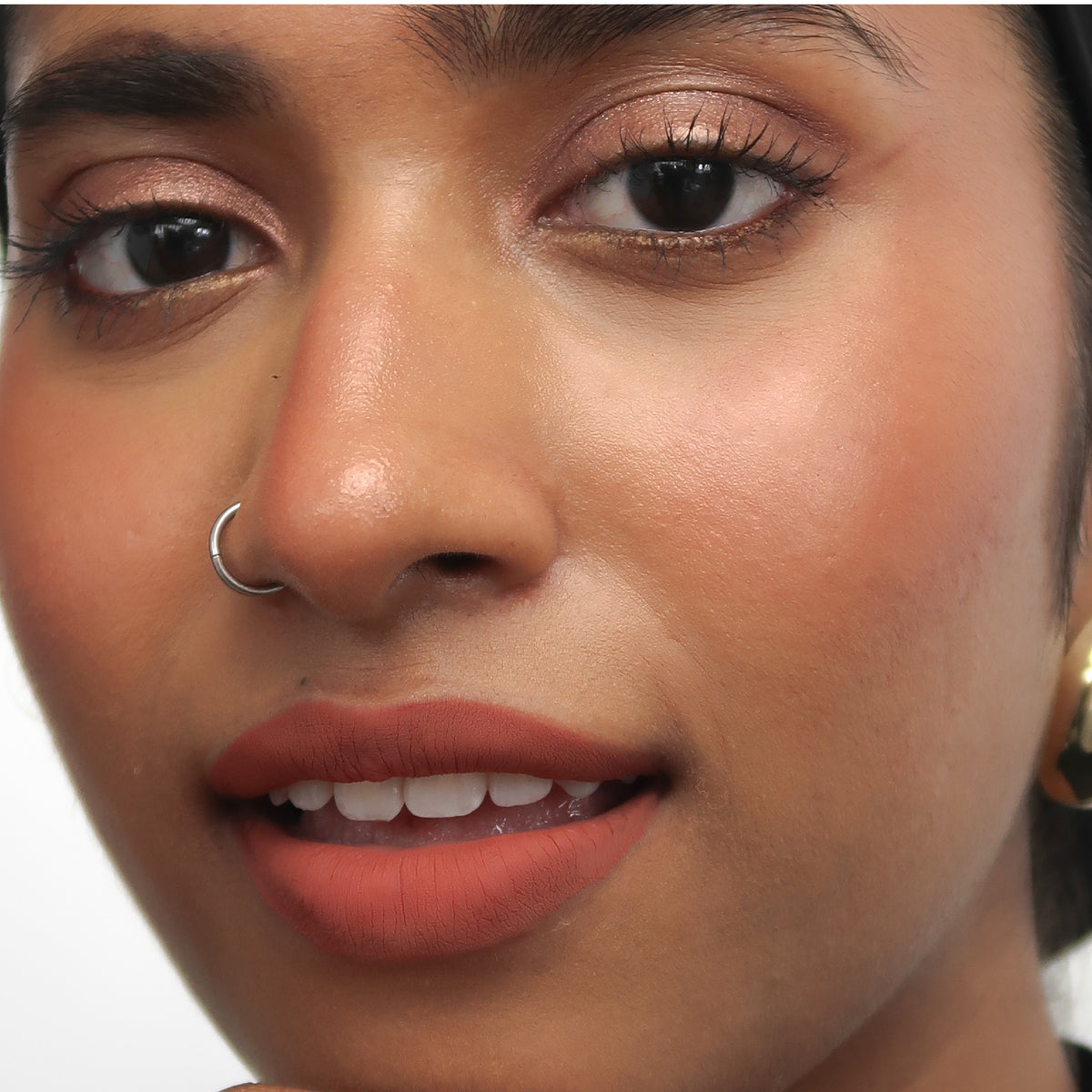Peptide Hydra-Matte Lipstick in Born Rich on tan skin