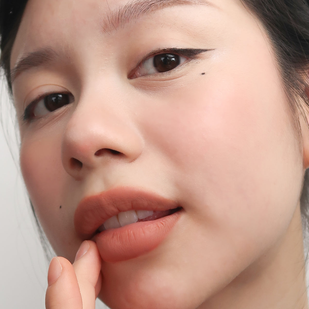 Peptide Hydra-Matte Lipstick in Cookie on fair skin