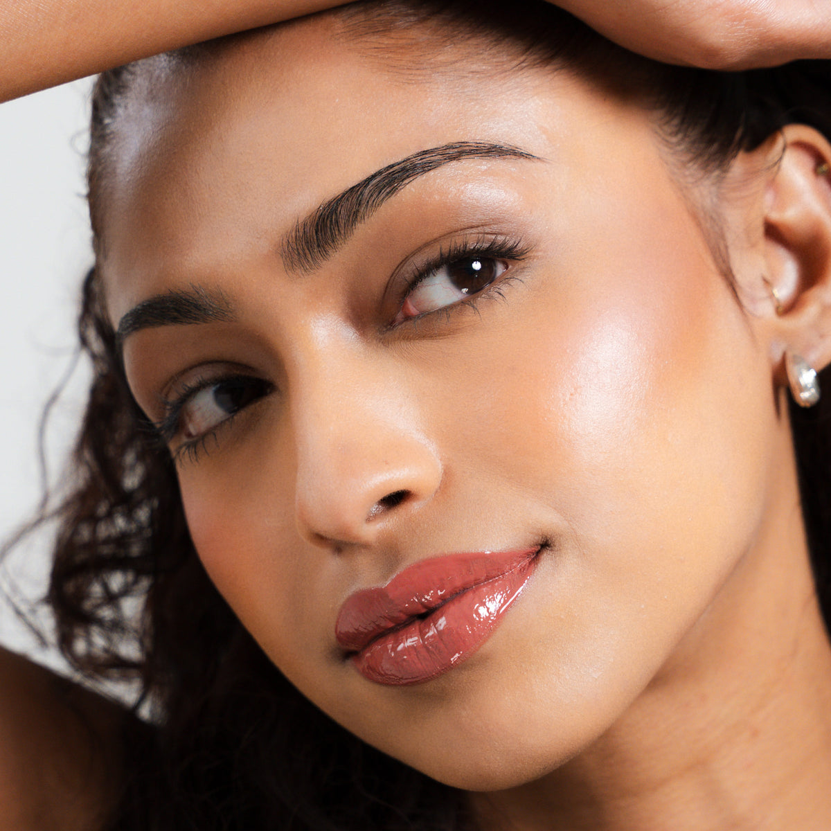 Peptide Glo Lip Glaze in Veil on tan skin